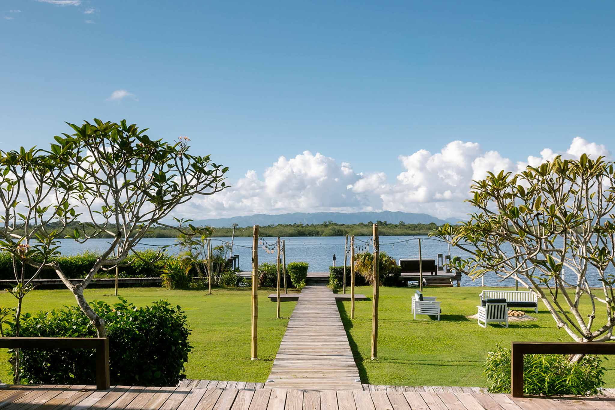 Wooden boardwalk stretching along the lagoon side at Umaya Resort in Placencia